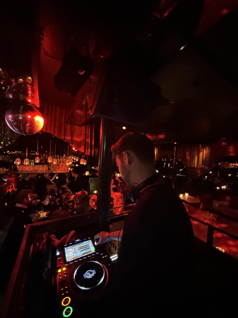 DJ Werner bag pulten på natklub i København med discokugler og rød belysning